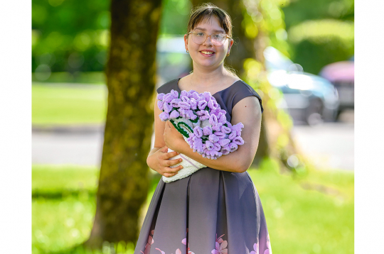 Jaunā rokdarbniece Paula Šupiņa ar savu tamborētu ziedu pušķi.