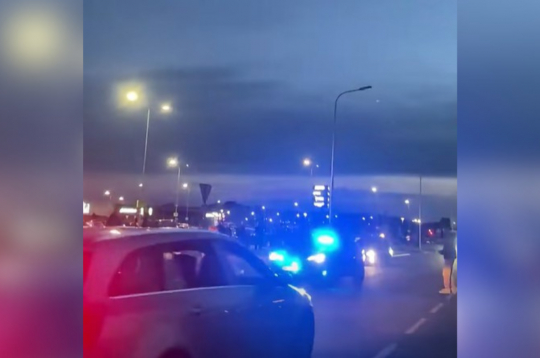 Valsts policijas auto ar mirgojošām bākugunīm pakaļdzīšanās laikā.