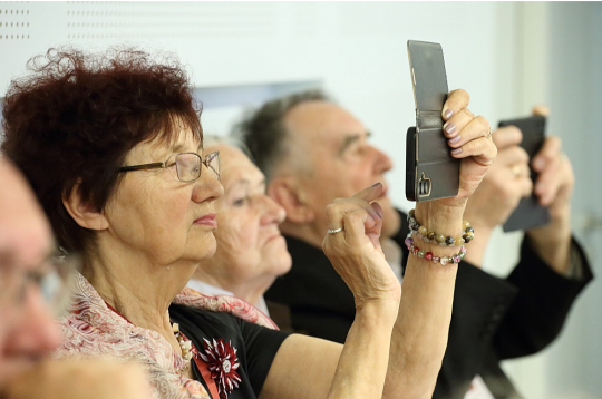Pasākuma norisi seniori iemūžināja gan ar pierakstiem blociņos, gan ar fotogrāfijām telefonos.