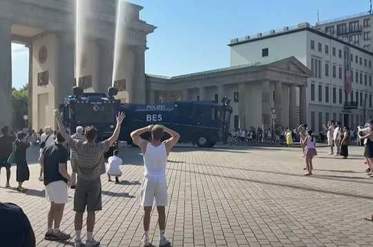 Vācijā pie Brandenburgas vārtiem cilvēki varēja veldzēties zem policijas auto "izšautajām" ūdens strūklām.