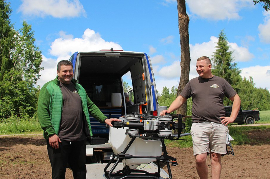 Jaunais saimnieks Elvis Bartkevičs (no labās) un saimniecības darbinieks Andrijs optimistiski lūkojas uz nākotnes tehnoloģiju – agrodronu – izmantošanu "Riekstiņu Amatnieku" tīrumos.
