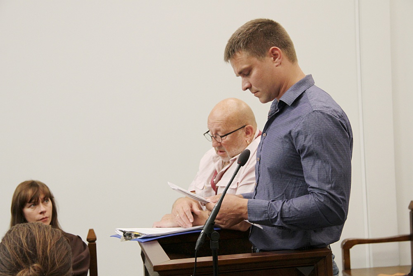 Apsūdzētais Valerijs Lazarevs (no labās), viņa tulks un cietušā jaunieša advokāte Santa Oborenko.