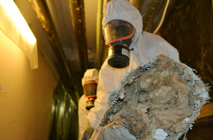 Azbestu saturošo siltumizolācijas materiālu nomaiņa Rīgas Dzemdību namā. Darbinieki saskaņā ar darba likumdošanu izmanto speciālo apģērbu un respiratoru maskas. Telpās pirms un pēc darbu veikšanas mēra azbesta piesārņojumu.