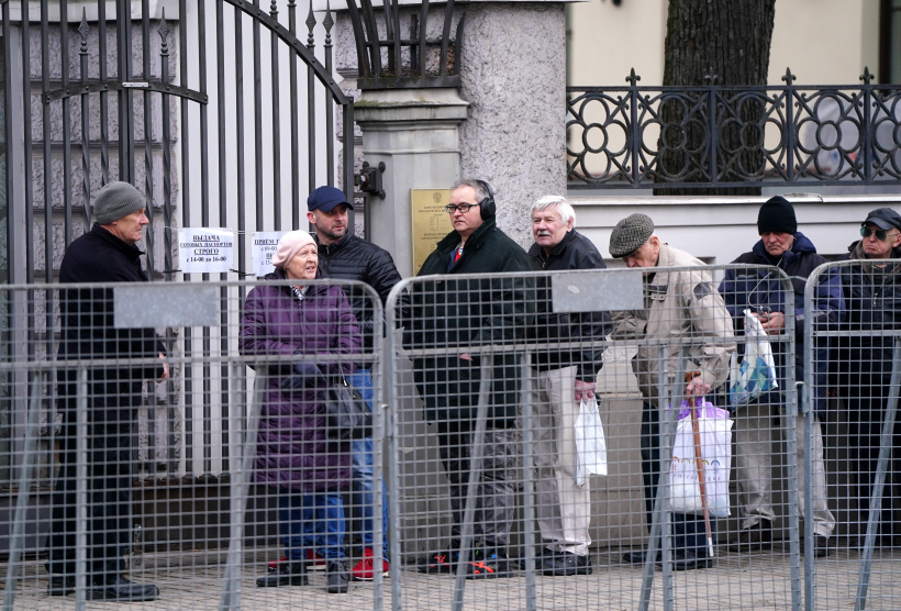 Cilvēki stāv rindā pie Krievijas vēstniecības ēkas Rīgā, kur iespējams nobalsot Krievijas prezidenta vēlēšanās.