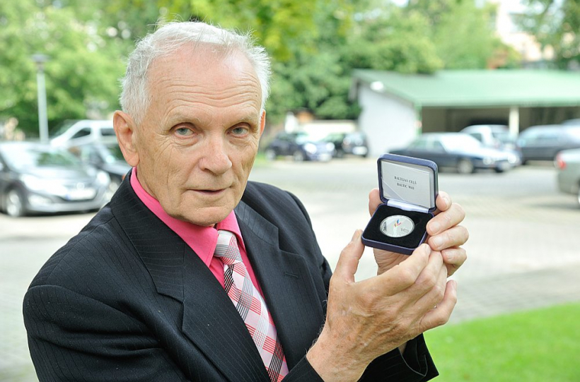 Andris Grīnbergs 2014. gadā ar Latvijas eiro kolekcijas monētu "Baltijas ceļš 1989–2014".