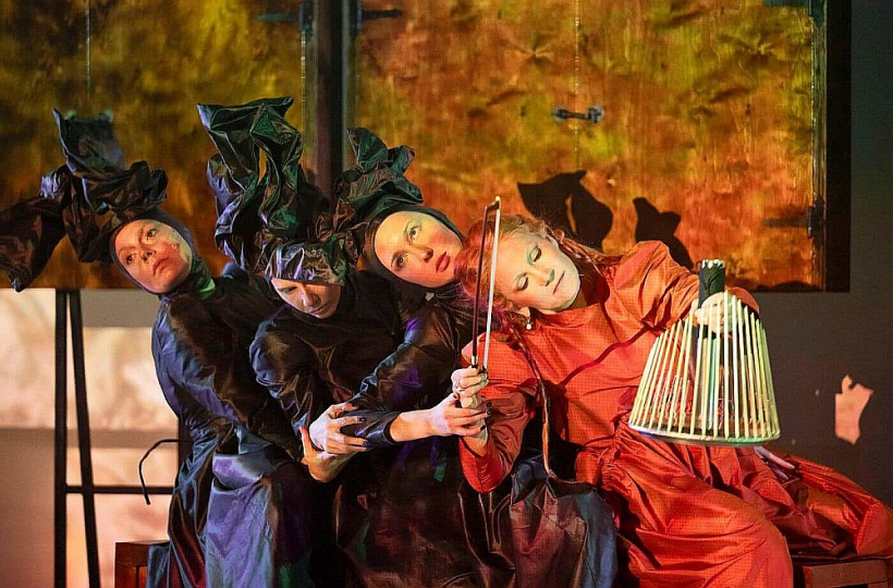 Centrālā tēla ietilpību izceļ īpašā MAREUNROL’S izstrādātā krāsu dramaturģija tērpos un rituāli pārģērbšanas procesi. Lomās: (no kreisās) Natālija Živeca, Adriana Tatjana Začeste, Elīna Bartkeviča, Veronika Plotņikova.