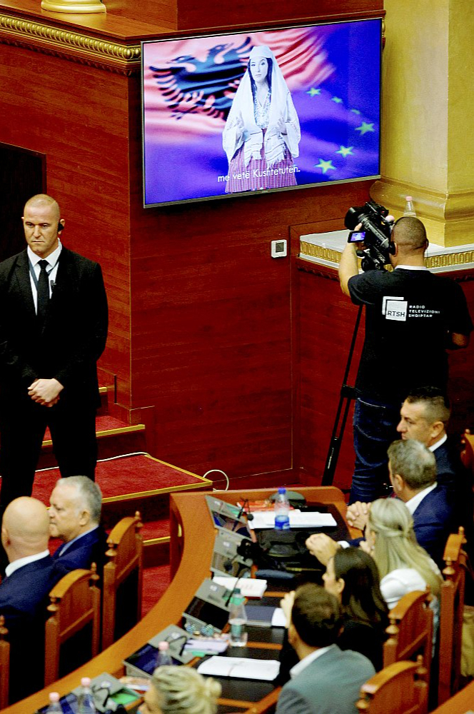 Albānijas jaunā mākslīgā intelekta ģenerētā ministre "Diella" uzstājas parlamenta sēdē jaunās valdības balsojumā 2025. gada 18. septembrī Tirānā. Tā pirmo reizi vērsās pie parlamenta, uzsverot, ka tās uzdevums ir "nevis aizstāt cilvēkus, bet palīdzēt viņiem".