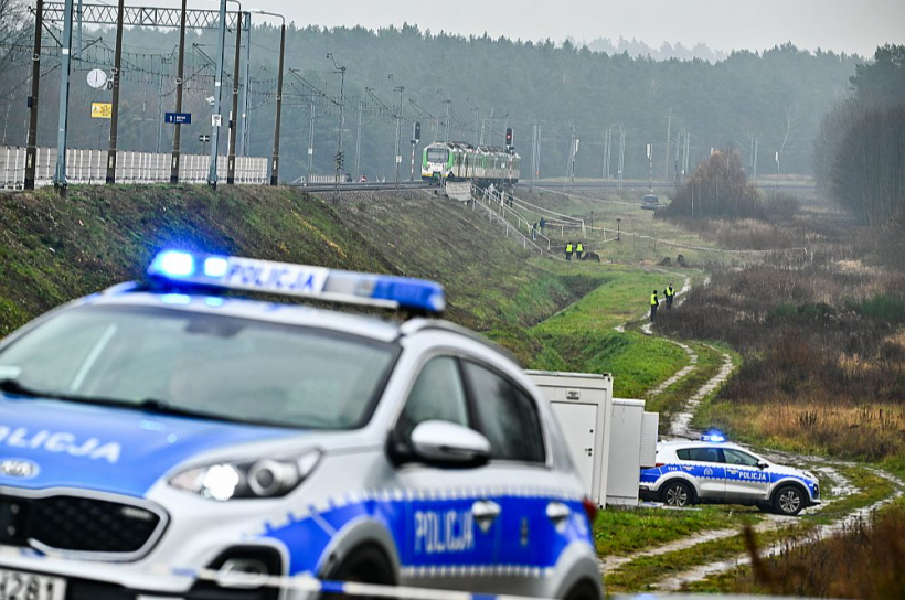 Diversanti 15. novembra vakarā, izmantojot militāras klases sprāgstvielu, izspridzināja dzelzceļa sliedes gabalu. Pāri bojātajai vietai pārbraukuši pat vairāki sastāvi, pirms defektu pamanīja. Laimīgas sakritības dēļ posts nevienam vilcienam netika nodarīts, bet katastrofa agrāk vai vēlāk notiktu. Attēlā: sliežu spridzināšanas vietā pie Mikas stacijas Polijas tiesībsargājošie dienesti veic izmeklēšanu.