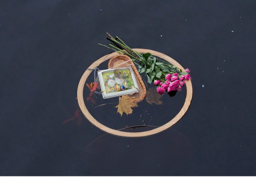 Vietā, kur automašīna no krastmalas iebrauca Daugavā, cilvēki nolikuši ziedus un svecītes, pieminot bojāgājušo sievieti.