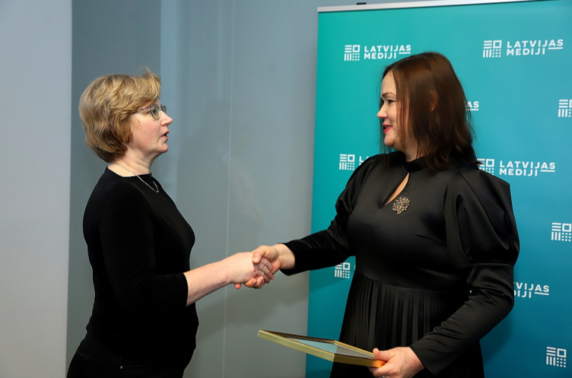 Redaktoru padomes priekšsēdētāja vietniece Ieva Ēvalde (no labās) sveic izdevniecības "Latvijas Mediji" atbildīgo redaktori Lindu Kusiņu-Šulci.