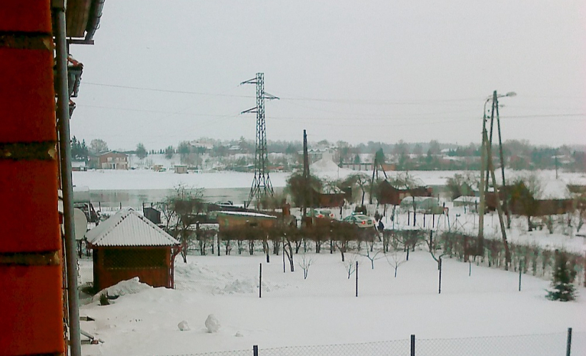 Apšaudes brīdis 2011. gada 25. janvārī Jēkabpilī Daugavmalā. Fotografēts no tuvējās mājas. Var redzēt, ka bandītu auto durvis vaļā, noslēpies kursants.