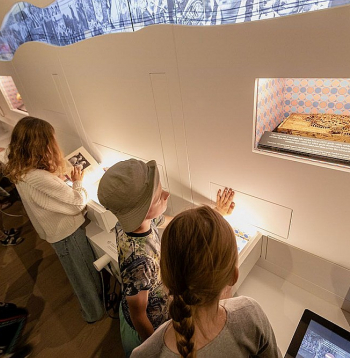 Pirmā stāva saturu veido četri objekti – "Līgo karogs", interaktīvā dārgumu siena "Laika upe", kormūzikas klausīšanās krēsli un multimediāla instalācija "Lielākais koris pasaulē".