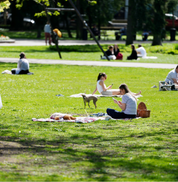 Cilvēki pavasarīgā maija dienā Vērmanes parkā Rīgā.
