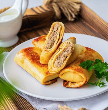 Ar gaļu pildītas pankūkas.
