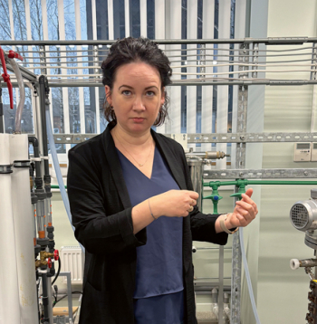 Zinātņu doktore Linda Mežule demonstrē projekta vajadzībām patentēto daudzpakāpju membrānu filtru. Ar to no cukura šķīduma atdala enzīmu nesašķeltās daļiņas.