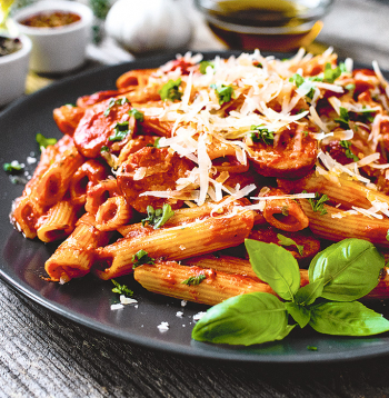 Penne ar cūkas krūtiņu un aso tomātu mērci.