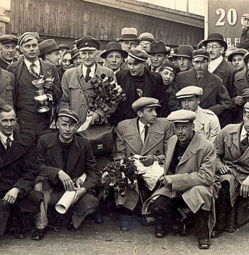 Latvijas basketbola izlases sagaidīšana Rīgas dzelzceļa stacijā 1935. gada 8. maijā. Priekšplānā J. Lidmanis. No kreisās 1. rindā – R. Dekšenieks, E. Andersons, M. Grundmanis, V. Melderis, A. Anufrijevs. 2. rindā pirmais – Dž. Raudziņš, komandas kapteinis R. Jurciņš ar izcīnīto kausu – sudraba vīna trauku, Kristaps Voldemārs Baumanis.