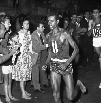 Baskājainais Abebe Bikila Romas olimpiskajā maratonā priekšā marokānim Rhadi ben Abdesalamam. Etiopietis kļuva par pirmo un vienīgo skrējēju moderno olimpisko spēļu vēsturē, kurš maratonā uzvarējis, skrienot bez apaviem.