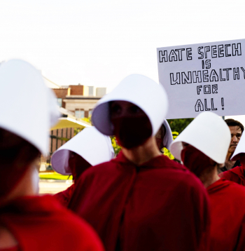 Protestētāji, tērpušies seriāla “Kalpones stāsts” kostīmos, pie Minesotas Universitātes Nortropa auditorijas Mineapolē 2025. gada 22. septembrī, kur notika “American Comeback Tour” pasākums. To vadīja politiskais komentētājs Maikls Noulss pēc tam, kad šī mēneša sākumā tika nogalināts Čārlijs Kērks.