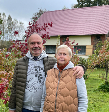 Aija Dzintra un Dainis Paukšēni 20 gados spējuši iekopt bagātīgu
ogulāju dārzu, kurā aug un ražo arī neparastāki augi. Attēlā: saimnieki savā dārzā, aiz muguras redzama māja, kurā ierīkota telpa ekskursantu grupu uzņemšanai.