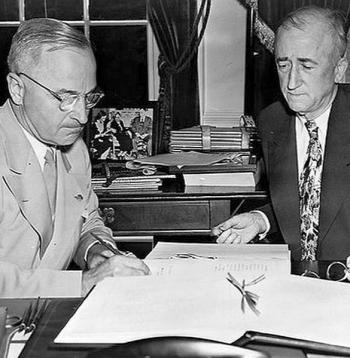 ASV valsts sekretārs Dž. Bērns (no labās) pasniedz ANO Hartu parakstīšanai prezidentam H. Trumenam.