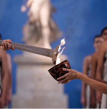 Milānas–Kortīnas olimpisko spēļu uguns tika iedegta, atkāpjoties no tradīcijām, jo bija bažas par nelabvēlīgiem laika apstākļiem.