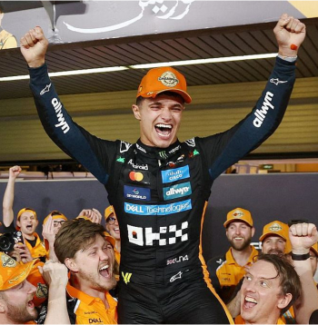 2025. gada F-1 čempions Lando Noriss uz "McLaren" komandas darbinieku pleciem. Noriss pirmo reizi kļuva par autosporta prestižāko sacensību uzvarētāju, no troņa gāžot iepriekšējo četru gadu uzvarētāju Maksu Verstapenu.
