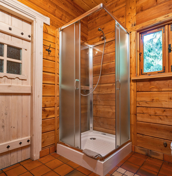 Guļbūvē ierīkota duškabīne ar stikla sienām.