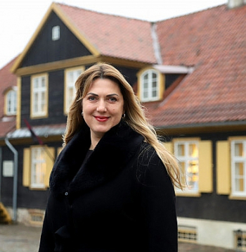 Kuldīgas novada domes priekšsēdētāja Inese Astaševska ar veco Kuldīgas rātsnamu fonā.