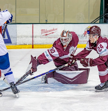 Latvijas junioru izlases vārtsargs Nils Mauriņš un uzbrucējs Daniels Serkins pārbaudes spēlē pret Slovākiju cenšas nosargāt savu vārtu drošību.