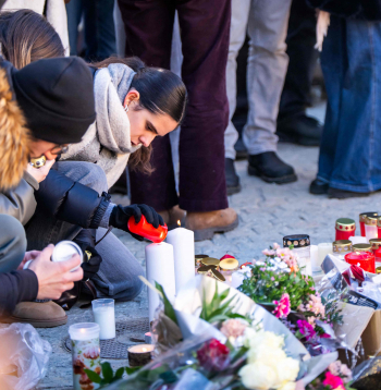 Sērotāji iededz sveces, pulcējoties pie improvizēta piemiņas memoriāla, lai noliktu ziedus, sveces un atvadu vēstījumus pie bāra Constellation 2026. gada 4. janvārī Kranmontanā, pieminot Jaungada naktī notikušā ugunsgrēka upurus greznajā Alpu slēpošanas kūrortā.