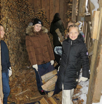 Malku no šķūnīša uz skolas ēku nes Aksels (no kreisās), Daniela un Melānija.