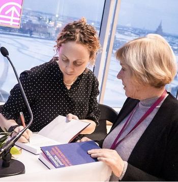 Vēsturniece Una Bergmane (no kreisās) grāmatas "Nenoteiktības politika: ASV, Baltijas jautājums un Padomju Savienības sabrukums" atvēršanā sniedz autogrāfus.