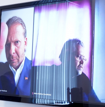 Aleksejs Rosļikovs (ekrānā no kreisās) tiesas sēdes laikā Rīgas pilsētas tiesā.