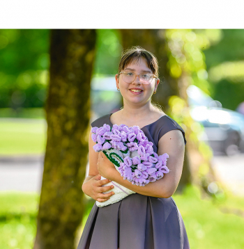 Jaunā rokdarbniece Paula Šupiņa ar savu tamborētu ziedu pušķi.