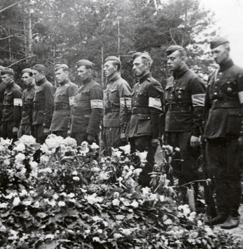 Bijušo Latvijas armijas karavīru un aizsargu – tobrīd Vācijas kārtības
dienesta darbinieku ierinda  pie padomju okupācijas Baigā gada
upuru masu kapa. 1941. gada vasara.