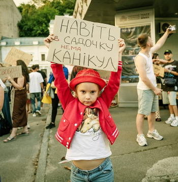 Simtiem ukraiņu vairākas dienas Kijivā piedalījās protesta akcijās pēc Ukrainas aizsardzības ministra Mihailo Fedorova atcelšanas no amata. Daudzi no protestētājiem pauda neapmierinātību ar reformu trūkumu armijā. Uz šīs protesta dalībnieces plakāta ukraiņu valodā rakstīts: "Pat bērnudārzā nav brīvlaika". Tas ir kā satīrisks sabiedrības pārmetums Ukrainas augstākajai vadībai par to, ka kara laikā nemitīgi tiek mainītas svarīgas amatpersonas, neļaujot tām pabeigt uzsāktās reformas. Plakāts arī simbolizē Ukrainas sabiedrības un jo īpaši jaunās paaudzes nogurumu no iekšējām politiskajām cīņām un pieprasījumu pēc stabilitātes un reālām reformām frontē, kur brīvdienu nav nevienam. Simtiem ukraiņu vairākas dienas Kijivā piedalījās protesta akcijās pēc Ukrainas aizsardzības ministra Mihailo Fedorova atcelšanas no amata. Daudzi no protestētājiem pauda neapmierinātību ar reformu trūkumu armijā. Uz šīs protesta dalībnieces plakāta ukraiņu valodā rakstīts: "Pat bērnudārzā nav brīvlaika". Tas ir kā satīrisks sabiedrības pārmetums Ukrainas augstākajai vadībai par to, ka kara laikā nemitīgi tiek mainītas svarīgas amatpersonas, neļaujot tām pabeigt uzsāktās reformas. Plakāts arī simbolizē Ukrainas sabiedrības un jo īpaši jaunās paaudzes nogurumu no iekšējām politiskajām cīņām un pieprasījumu pēc stabilitātes un reālām reformām frontē, kur brīvdienu nav nevienam.