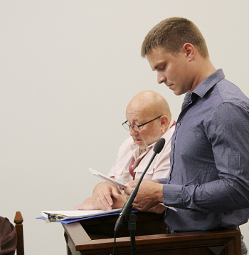 Apsūdzētais Valerijs Lazarevs (no labās), viņa tulks un cietušā jaunieša advokāte Santa Oborenko.
