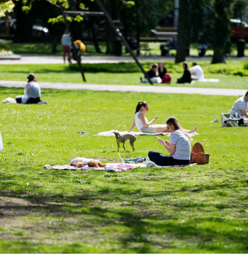 Cilvēki pavasarīgā dienā Vērmanes parkā Rīgā.