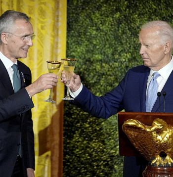 ASV prezidents Džo Baidens (no labās) un NATO ģenerālsekretārs Jenss Stoltenbergs Baltajā namā rīkotās vakariņās saskandina glāzes.