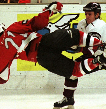 Latvijas izlases leģendārā spēle 1997. gada 30. aprīlī Turku pilsētā pret Kanādu – aizsargs Artūrs Kupaks (no labās) liek lidot pa gaisu kanādiešu uzbrucējam Bobam Erejam.