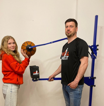 Jānis Gremzde ar meitu Skārletu pie basketbola metiena trenažiera.
