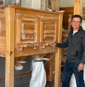 “Kaņepīšu” saimnieks Guntars Antonijs pie akmens dzirnavām, kurās maļ 12 dažāda smalkuma miltus.