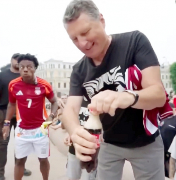 Kad Raimonds Vējonis mēģina attaisīt kolas pudeli, tās saturs izšļakstījās, atstājot uz pieminekļa traipus.