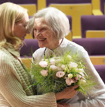 Latvijas Okupācijas muzeja direktore Solvita Vība (no kreisās) sveic Lidiju Lasmani pēc koncertuzveduma "Lidija 100" Latvijas Nacionālajā bibliotēkā.