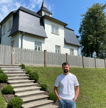 Jānis Vilciņš pie sava nama ar ieeju no Raiņa ielas.