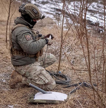 Ukrainas armijas karavīrs uzstāda "Starlink" antenu frontē pie Avdijivkas.