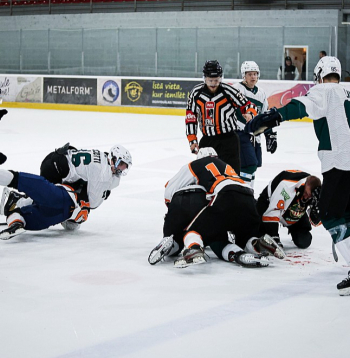 Hokeja kautiņš, kas nedaudz vēlāk pārauga nekontrolējamā agresijā, ar sišanu pa galvu, ķiveru svaidīšanu un treneru saplūkšanos. Tam par pamatu bija nacionālas dabas konflikts starp divām Latvijas amatieru komandām.