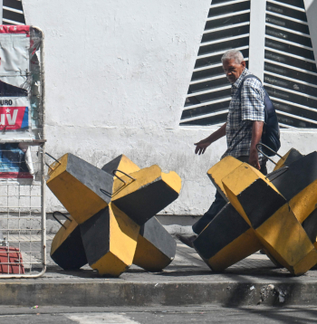 Vīrietis iet garām Venecuēlas prezidenta Nikolasa Maduro plakātam un prettanku barjerai Karakasā, 2025. gada 28. oktobrī. ASV spēki nogalināja 14 cilvēkus triecienos, kas iznīcināja četras, kā tiek apgalvots, narkotiku kontrabandā iesaistītas laivas Klusā okeāna austrumu daļā, otrdien paziņoja aizsardzības ministrs Pīts Hegsets.