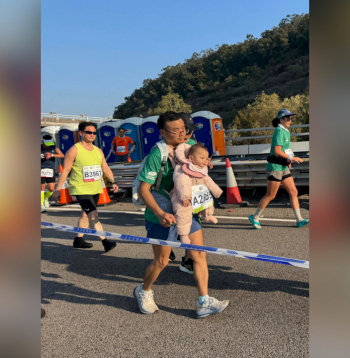 Maratona dalībnieks ar zīdaini.